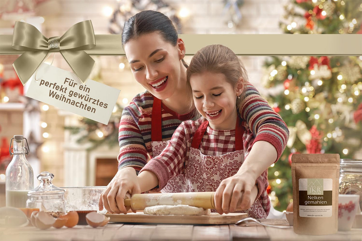 JKR Spices Nelken gemahlen im Doypack Weihnachtsmotiv Mutter und Kind backen gemeinsam in der Kueche mit Weihnachtsbaum Geschenkband und Schild Fuer ein perfekt gewuerztes Weihnachten