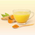 Goldene Milch im Glas mit Kurkuma und Ingwer auf hellem Hintergrund – cremiger Gewürzdrink als Inspiration