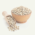 Weiße Pfefferkörner ganz in Holzschale mit Holzlöffel auf hellem Hintergrund Gewürz White Pepper Corns