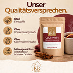 JKR Spices Glühweingewürz mit Qualitätsversprechen neben Gewürzen und einer Tasse Glühwein.
