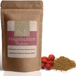 Hagebutten Pulver im braunen JKR Doypack mit fein gemahlenem Pulver und frischen Hagebutten daneben – fruchtiges Naturpulver für Smoothies, Tee und Küche.