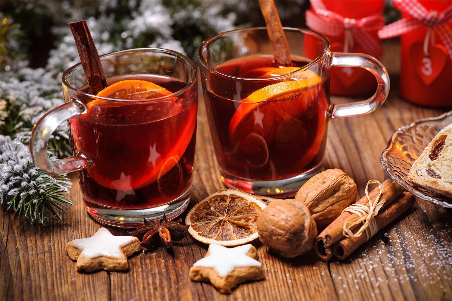 Glühwein in Glasbechern mit Orangen, Zimt und Sternanis – natürliche Präsentation der winterlichen Gewürzvielfalt