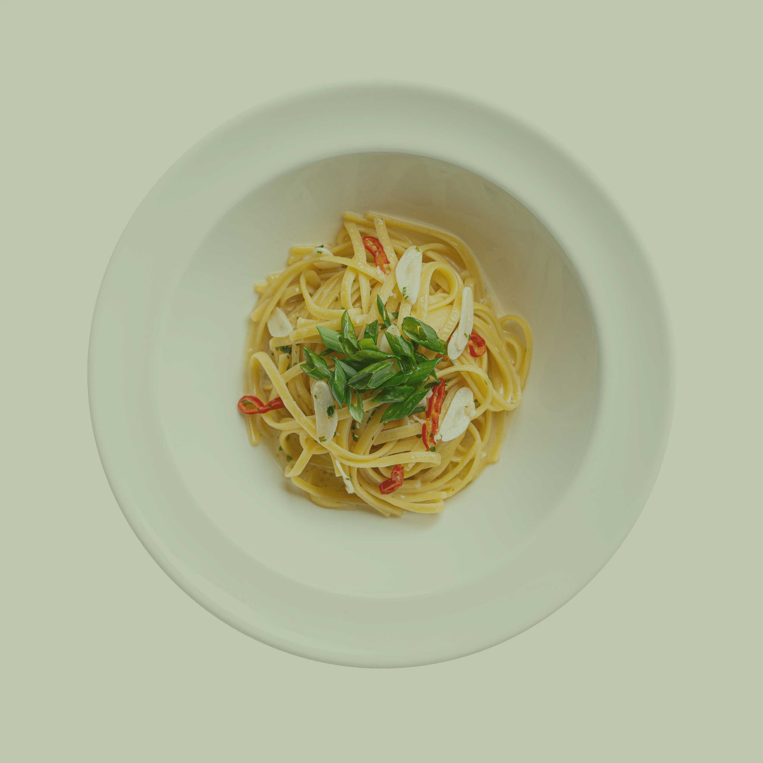Pasta Aglio e Olio Serviervorschlag mit JKR Gewürzmischung, Teller mit Spaghetti, Knoblauch Öl, Kräutern und Chili
