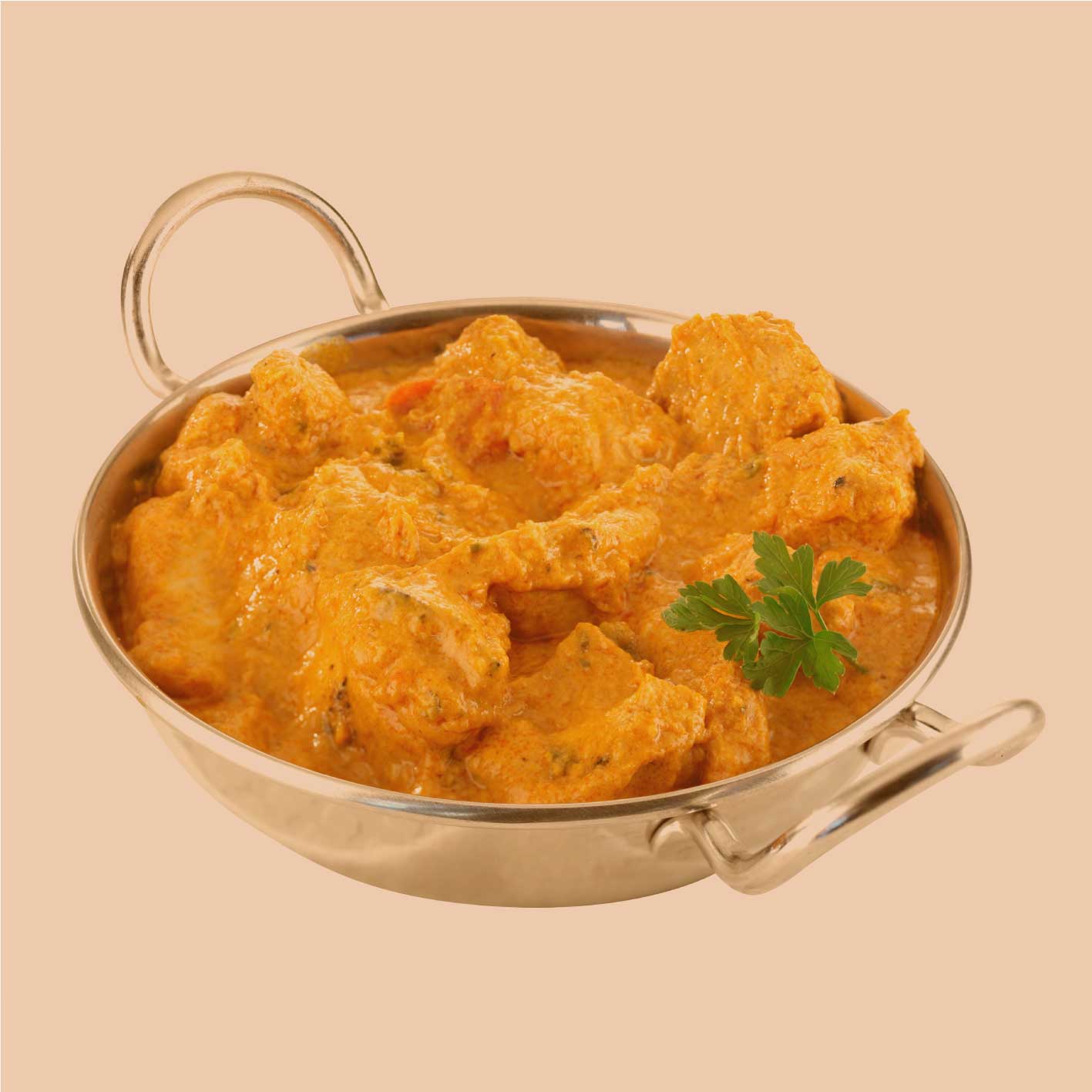 Madras Curry als cremiges Gericht in einer Metallpfanne – serviert mit frischer Petersilie auf hellem Hintergrund