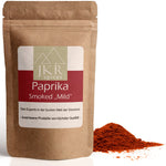 JKR Spices Paprika Smoked „Mild“ im braunen Doypack, geräuchertes Paprikapulver als roter Gewürzhaufen vor weißem Hintergrund