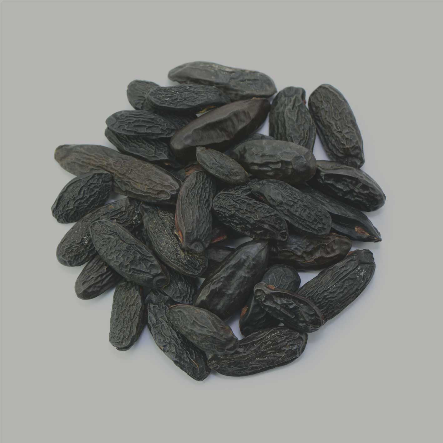 Tonkabohnen Nahaufnahme, ganze schwarze Tonkabohnen als Rohware auf hellem Hintergrund